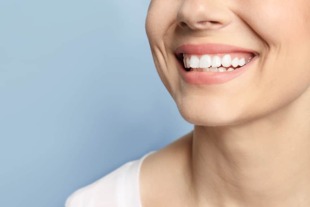 A close-up shot of a woman’s smile after getting dental implants.