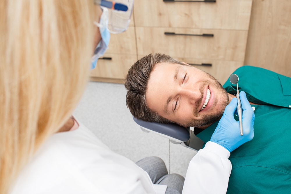 Man smiling and relaxing in dentist chair after receiving sedation dentistry in Plano. Man smiling and relaxing in dentist chair after receiving sedation dentistry in Plano.