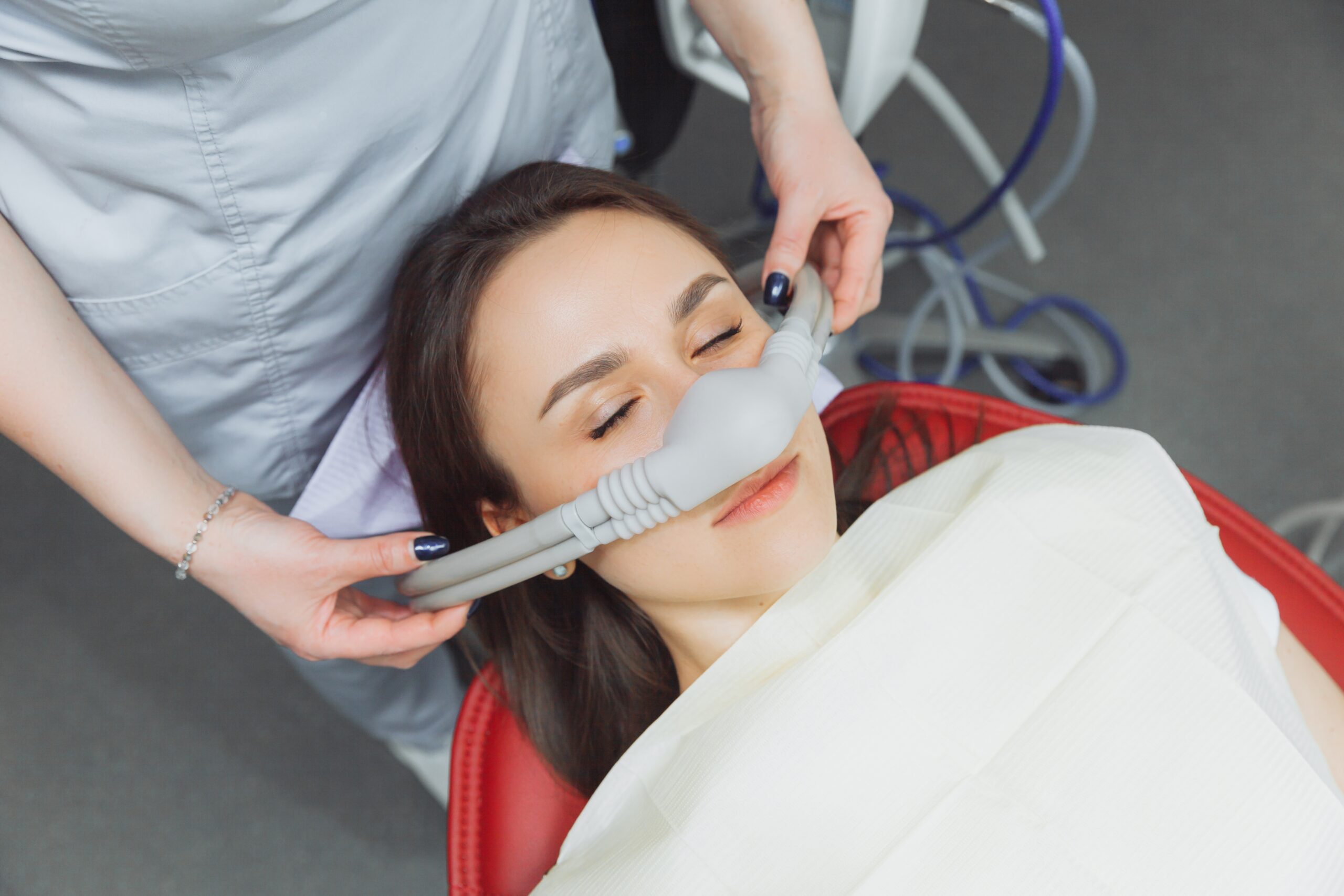 Woman in dentist chair with eyes closed receiving sedation dentistry treatment
