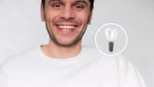 Man smiles showing a complete smile after replacing a missing tooth with a dental implant.